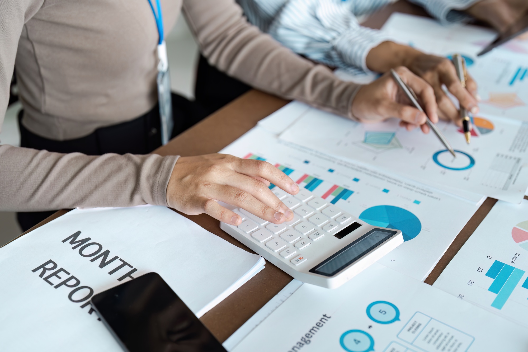 Business bookkeeper working with calculator to calculate business data summary report, accountancy